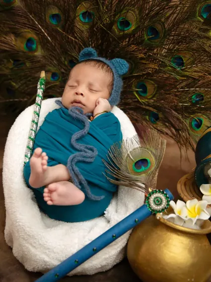 For the tiniest newborns, I use a comfortable basket and soft wraps to create this adorable sleeping Krishna look, complete with a tiny bonnet.
