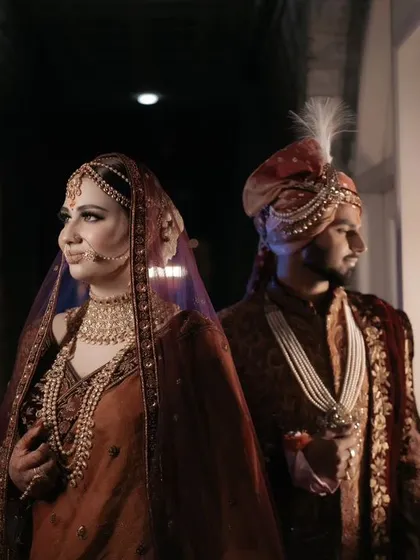 A moody and artistic portrait of the couple in a dimly lit corridor, the window light creating a dramatic and intimate feel.