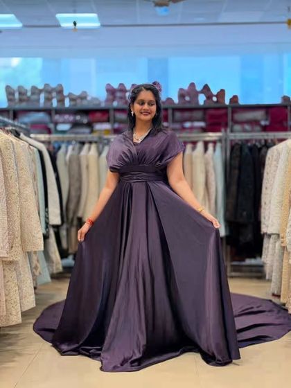 This deep purple satin gown with a long train exudes pure luxury. The elegant draping at the waist and the flowing fabric create a sophisticated and regal look for any formal event.