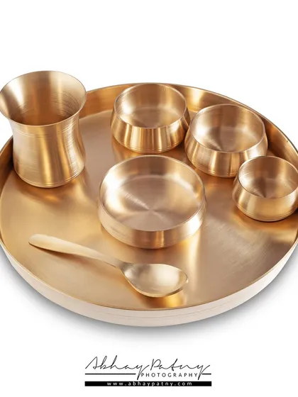 Clean, crisp, and ready for your online store. This e-commerce shot of a brass thali set was photographed against a pure white background to eliminate distractions and focus entirely on the product's form and metallic finish.