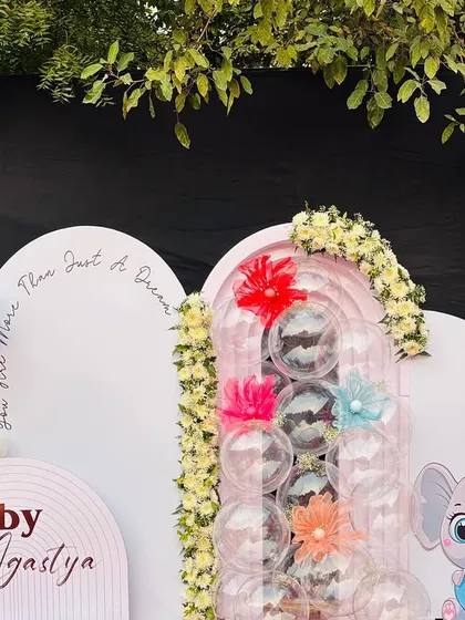 This wide shot shows the complete setup for the Kuan Pujan ceremony, highlighting the asymmetrical design of the backdrops and balloon arrangements.