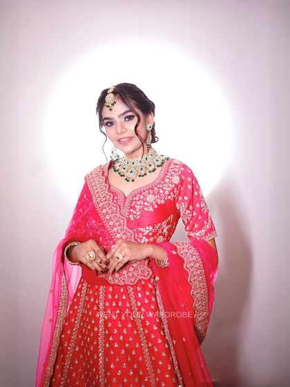 This vibrant pink lehenga is perfect for a bold bridal or sangeet look. The green emerald jewellery provides a beautiful contrast that will make your makeup pop.