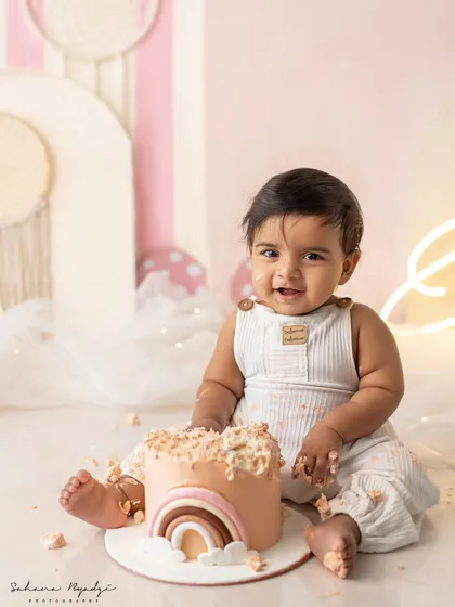 A happy baby boy, enjoying his rainbow cake. The pure joy on his face is what it's all about.