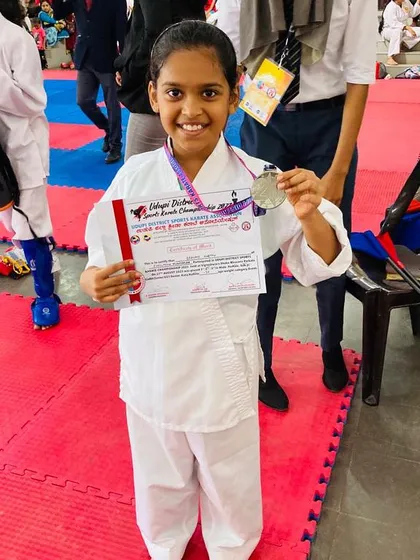 A young student all smiles after winning a silver medal at her first district-level competition.