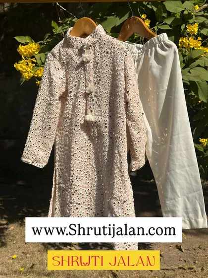 A beautiful mirror-work kurta and pant set for boys, shown here in a classic cream color.