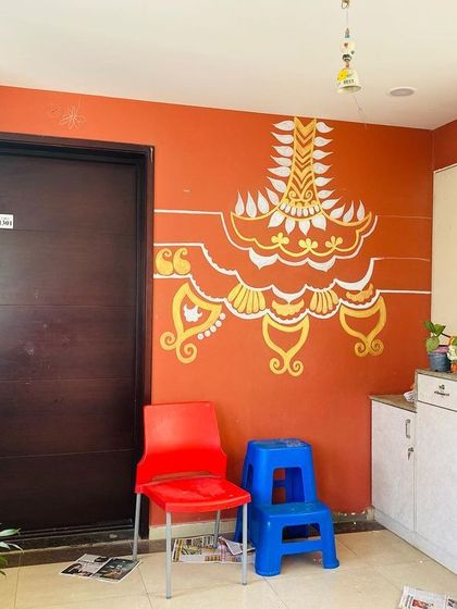 The mural taking shape. The first layers of gold and ivory are down, outlining the ethnic patterns that will soon fill the wall with harmony and joy.