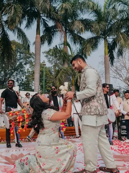 A modern proposal role-reversal! The bride gets down on one knee during a fun-filled event, a moment of joy and empowerment.