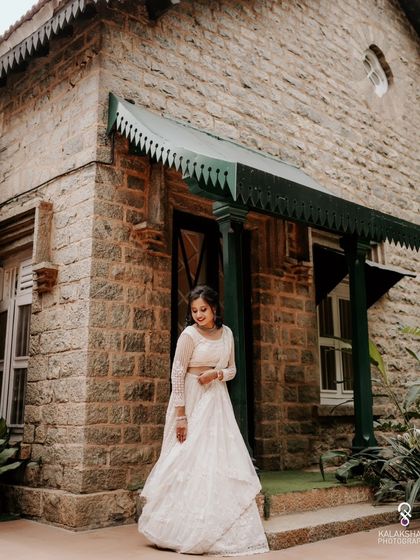 A full-length shot of the bride in her elegant white lehenga at her engagement.