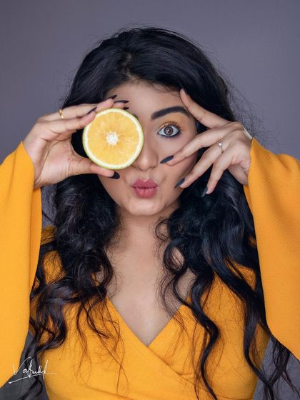 A duplicate of the playful 'orange slice eye' portrait. The model's fun expression is what truly brings this creative and colorful concept to life.