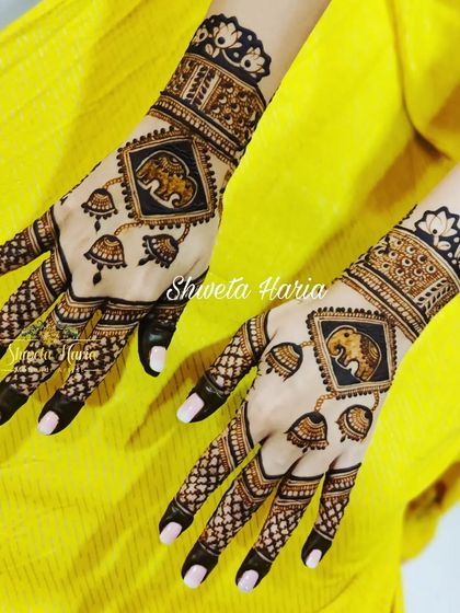 This stylish back-hand design features elephant motifs in diamond frames with hanging jhumkas, creating a modern yet traditional look.