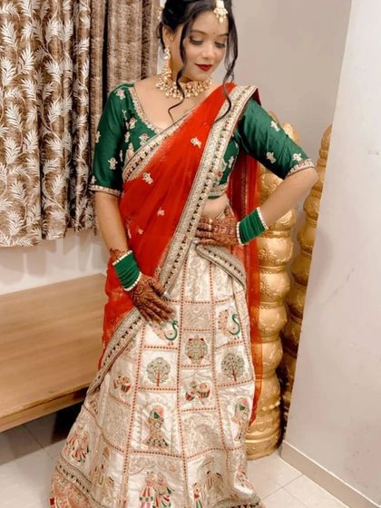 A unique white and red lehenga with peacock and tree motifs, perfect for a bride who wants a blend of tradition and artistry.