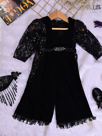 A flat lay of our black velvet jumpsuit, styled with matching accessories, showing a complete, ready to wear look.