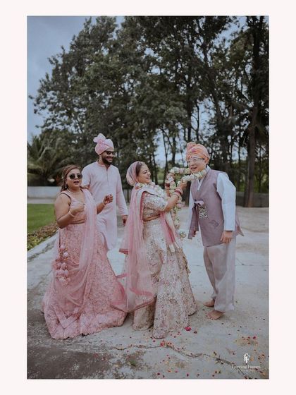 A fun, candid shot of the Varamala ceremony, with the family laughing and enjoying the moment.