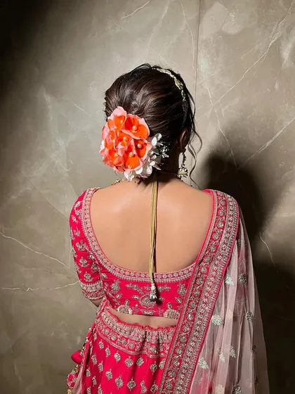 A side view of a textured bridal bun, showing how the fresh flowers are carefully placed to create a beautiful shape that works with the bride's overall silhouette.