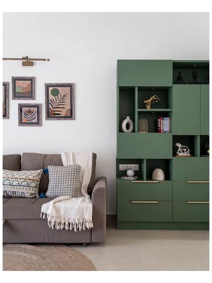 A detail of the green storage unit, which combines open and closed shelving with gentle indirect lighting. The artwork was created by the client's sister, adding a unique personal touch.