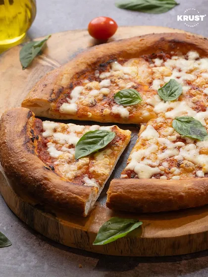 A perfectly baked sourdough pizza with a crispy crust, topped with fresh basil. In our classes, I teach the techniques to achieve this authentic pizzeria-style result at home.