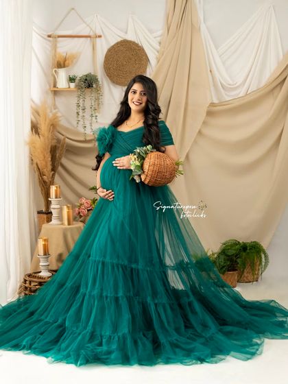 A lovely portrait showcasing the details of the green gown and the charming boho-inspired studio decor.