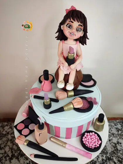 A cake for a little makeup lover. This design features a cute girl figurine surrounded by her own collection of edible makeup, including lipstick, brushes, and nail polish.
