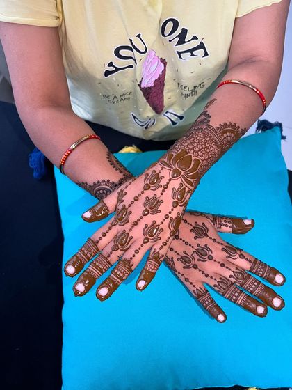 A lovely semi-bridal design featuring a trail of lotus motifs. This pattern is perfect for festivals or smaller functions, offering an elegant yet understated look.