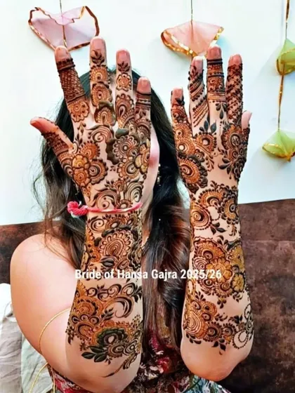 A happy bride showing off her full-coverage floral mehendi. The design is as vibrant and beautiful as her smile, perfect for her special day.