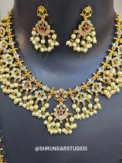 The matching earrings are designed to complement the delicate work on the necklaces perfectly.