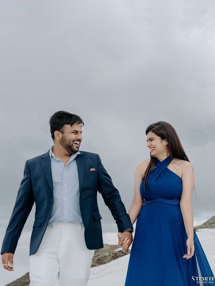 A joyful, walking shot of the couple, hand-in-hand in the snow.