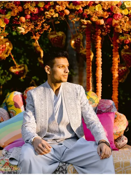 The groom, waiting in the golden light, surrounded by vibrant colors. A portrait of quiet anticipation just before the big moment.