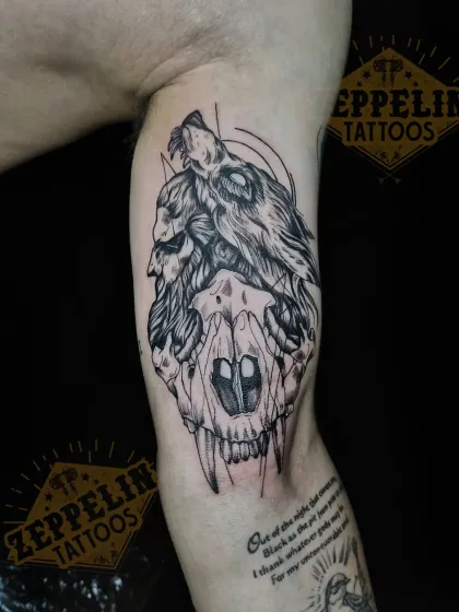 This tattoo combines a wolf and a skull, representing the duality of instinct and mortality. The sketch-like style adds a raw, energetic feel to the black and grey realism.