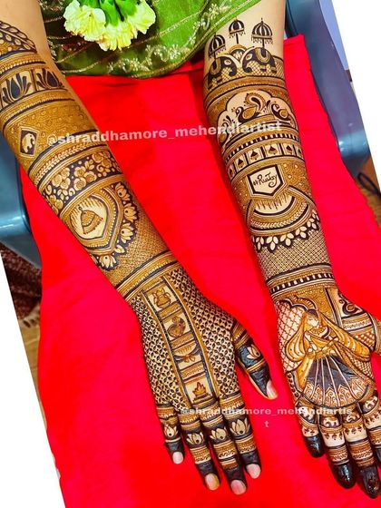 A custom design featuring the couple's initials 'M' and 'G'. The arms are adorned with palace architecture, swans, and a bride in a doli.