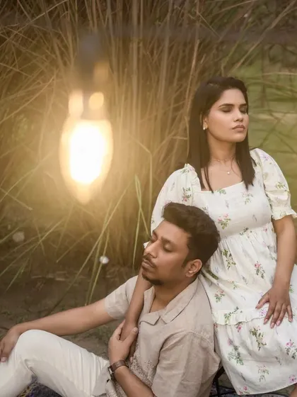 A close-up of the couple in a field, with a warm light bulb in the foreground creating a beautiful flare and a dreamy, magical effect.