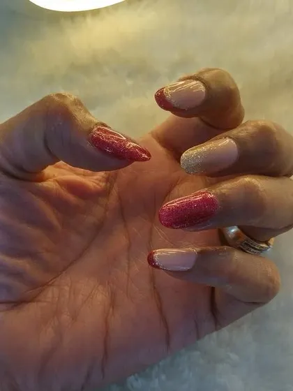 A closer look at the shimmery red and gold French tips. This design is perfect for brides who want a touch of color and sparkle.
