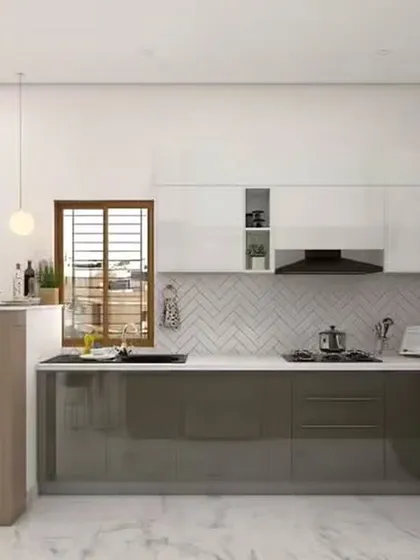 A compact breakfast bar transforms this kitchen into a multi-functional space for quick meals and morning coffee. The two-tone design with glossy grey lower cabinets and white uppers is complemented by a stylish herringbone backsplash.