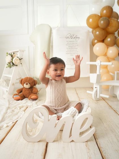 Hands up if you're one. This joyful shot captures the pure excitement of a first birthday celebration.