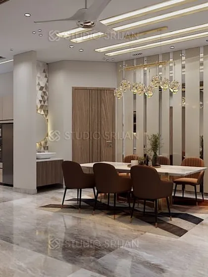 The dining area in the Bali Nagar residence, featuring a long table perfect for large gatherings, illuminated by modern chandeliers and set against a wall of vertical slats.