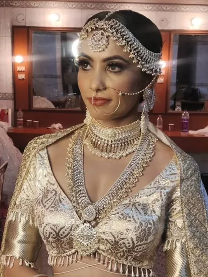 A repeat of the stunning silver-toned jewellery set with a white and gold brocade lehenga, showing its regal appeal from another angle.