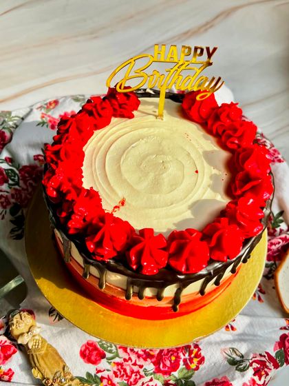 An overhead view of our Classic Chocolate Truffle Cake, showing the beautiful red piped roses and rich chocolate drip.