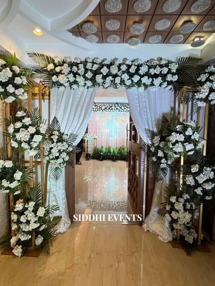 An entrance defined by pure elegance. We used flowing white curtains and a gate completely enveloped in pristine white florals to create an enchanting and dreamy passageway.