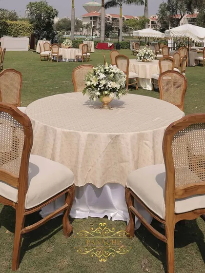 A closer view of the guest table setup, with beautiful wooden-backed chairs and a simple, elegant floral centerpiece.