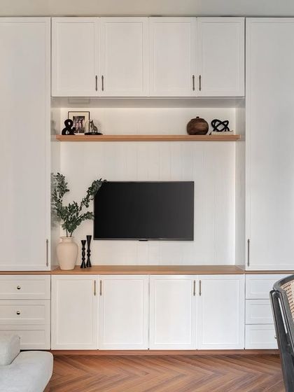 This study room is designed to double as an entertainment room. It features a clean white matte PU desk, floating shelves, and shaker-style storage units, catering to all home office requirements with elegance.