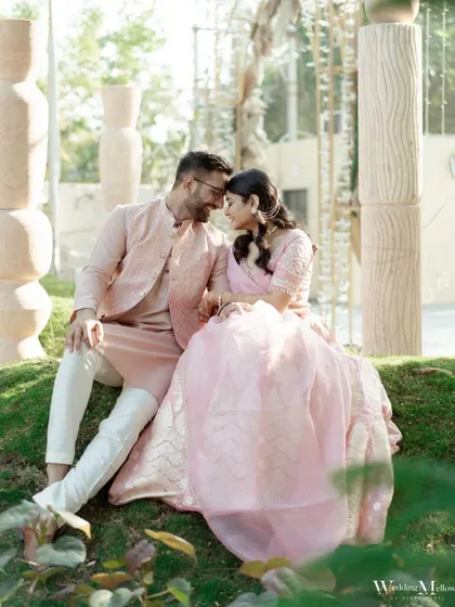 A serene and romantic portrait of the couple, finding a quiet moment together amidst their Haldi celebrations. Dressed in pink, they share a look of love and contentment.