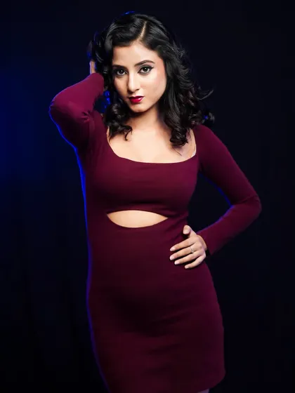 A full-length shot of the model in a maroon dress, showing how the makeup completes the entire look.