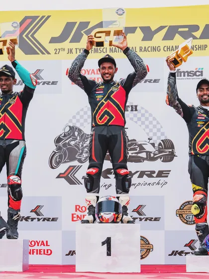 A moment of victory for our chief instructor on the podium at the Royal Enfield GT Cup, celebrating with his fellow competitors.
