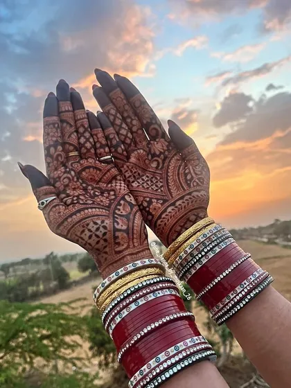 A perfect sunset shot showing off the gorgeous henna stain. The rich color of the mehndi against the warm light is just magical, especially with the bridal chura.