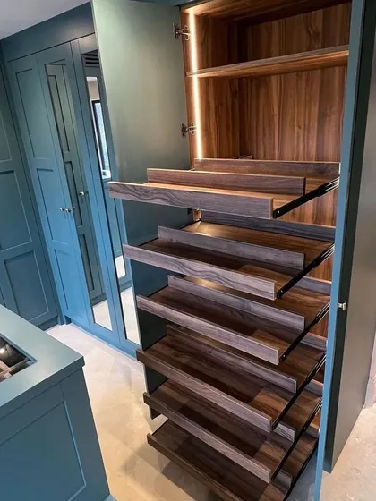 It's the details that matter. This close-up shows our custom pull-out shoe racks, crafted from rich walnut veneer. Each shelf is angled for easy viewing and access, keeping your footwear collection organized and in pristine condition.