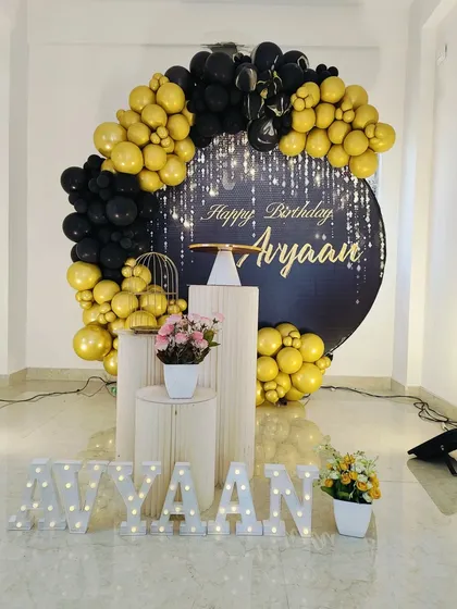 The full black and gold setup with pedestals and marquee letters, creating a very glamorous and celebratory atmosphere.