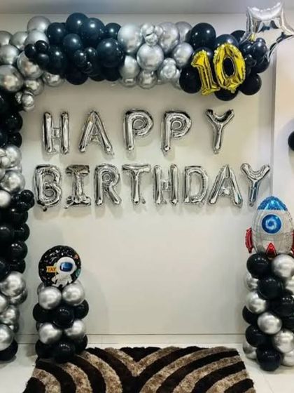 An outer space adventure theme for a 10th birthday. I created a balloon arch with black and silver balloons, "Happy Birthday" foil letters, and added astronaut and rocket ship balloon figures.