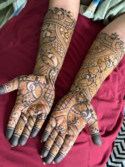 A flowing, paisley-style design with peacock details. This type of pattern is very graceful and creates a sense of movement up the arm.