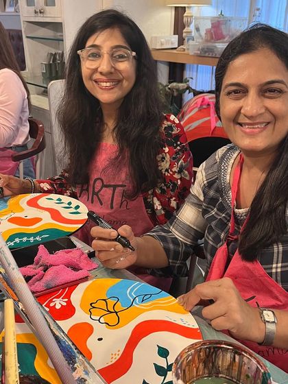 Two friends enjoying the process of painting their own decorative clocks at a private party. It's a wonderful way to bond and create something beautiful together.