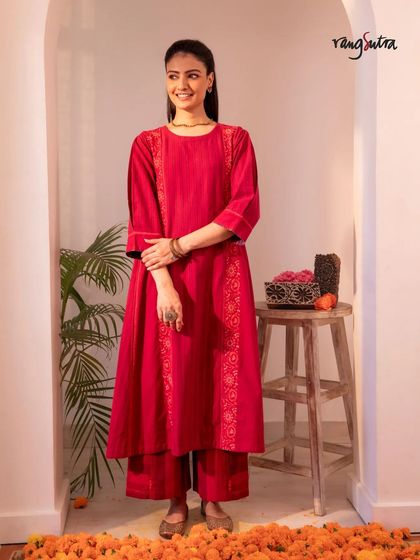 A full look at our red Haveli kurta set. The combination of the A-line kurta and matching pants, both adorned with Chikankari embroidery, creates a striking festive ensemble.