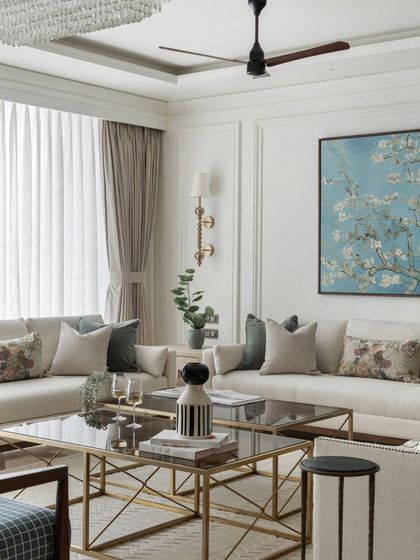 A closer look at the English-inspired details in this living room. The combination of neutral sofas, classic wall mouldings, and a beautiful piece of art creates a serene and sophisticated corner for relaxation.